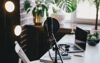 Auf einem Schreibtisch ist Podcastequipment aufgebaut.