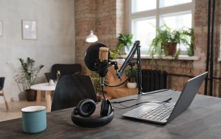 Auf einem Schreibtisch ist Podcastequipment aufgebaut.