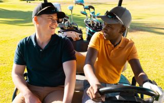 Zwei Personen fahren in einem Golfcar.