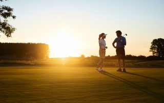 Zwei Personen spielen Golf.