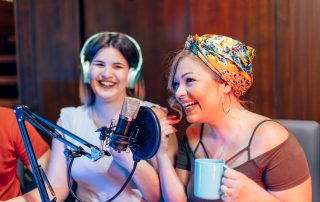 Zwei Frauen nehmen gemeinsam einen Podcast auf.