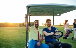 Zwei Männer fahren im Golfcart.
