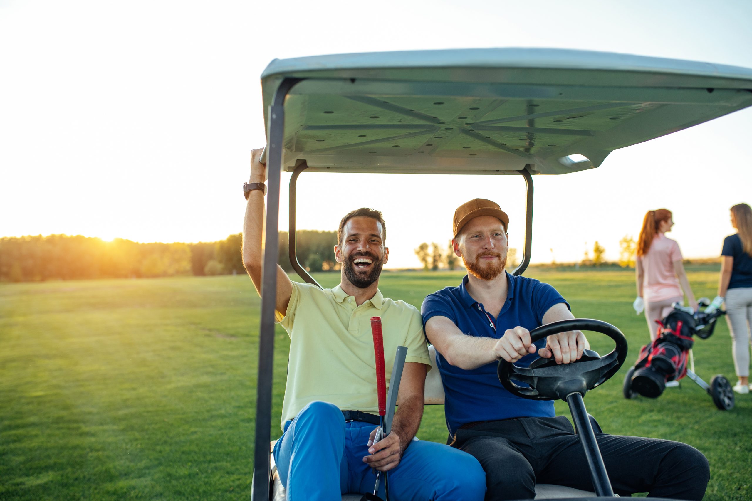 Zwei Männer fahren im Golfcart.